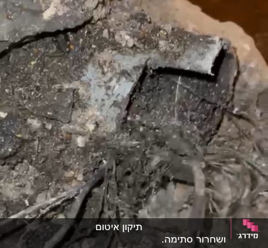 צינור שבור מכוסה באדמה וענפים
